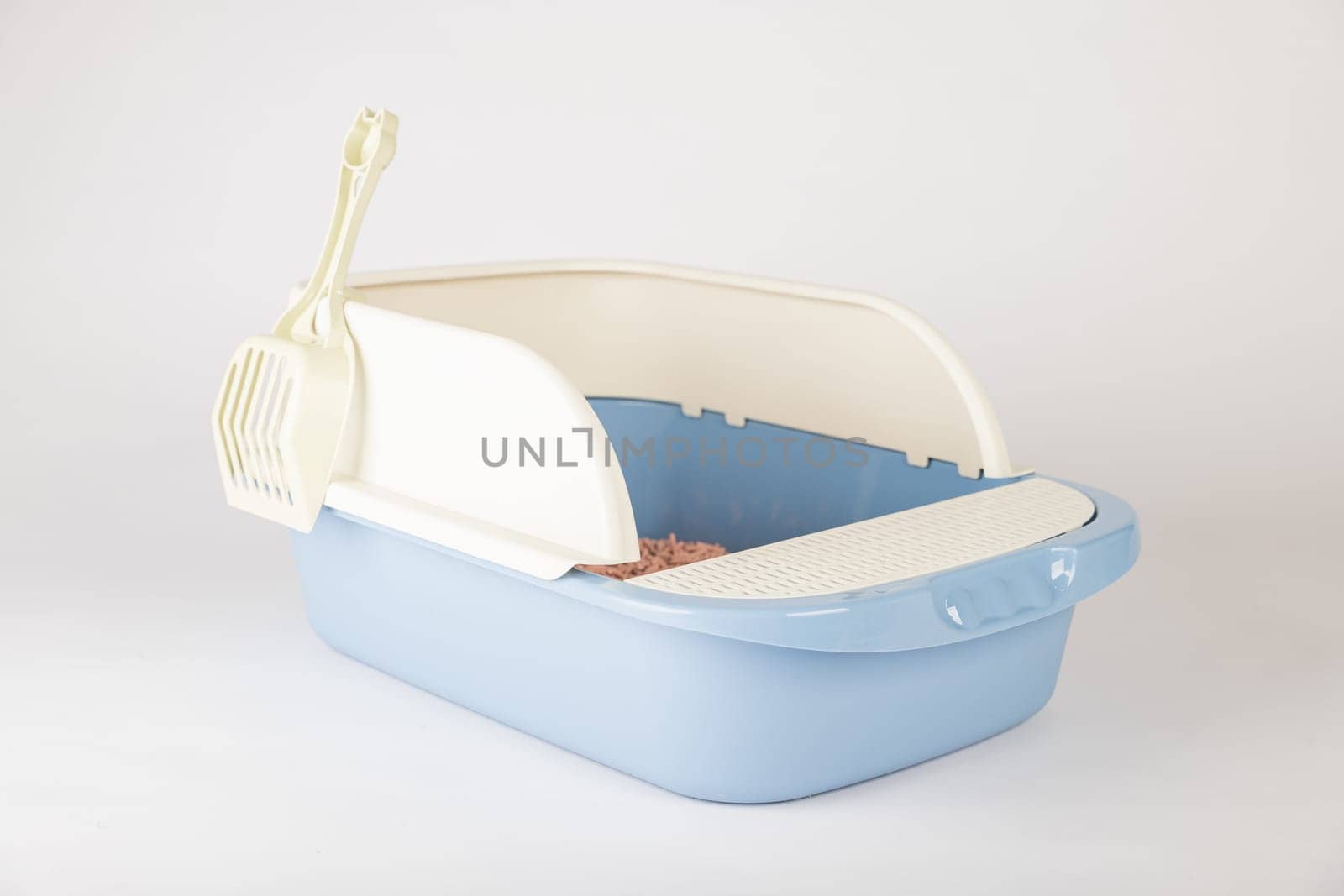 An isolated cat litter toilet tray with scoop on a clean white background. This plastic crate is a hygiene and care essential for your furry friend.