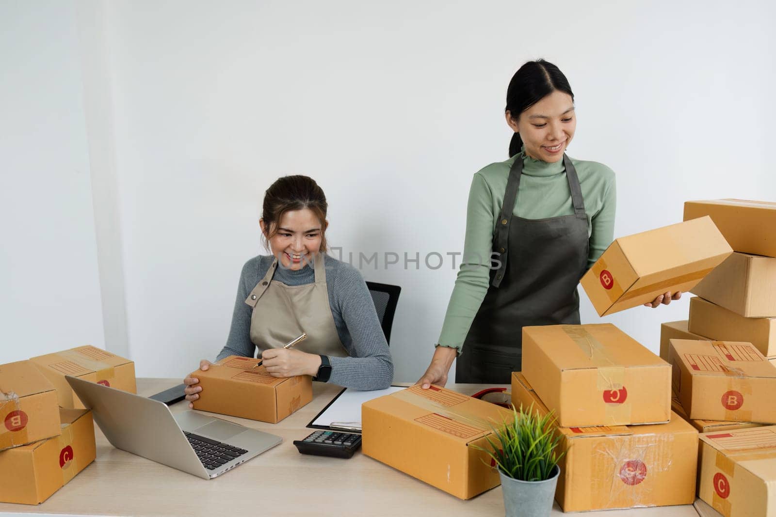 Asian woman write parcel box to prepare for delivery to customer. e-business concept.