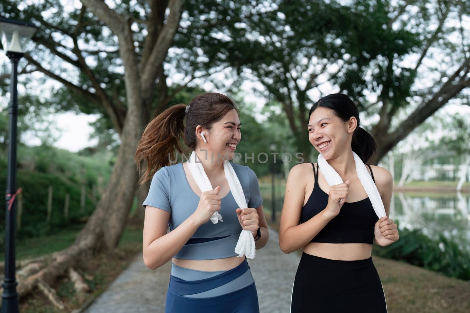 Two happy women going for sunrise running. Women in track suits running at park.