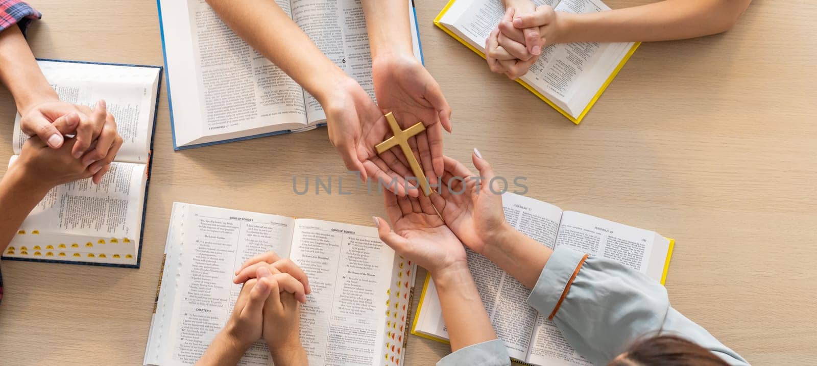 Close-up women prayer deliver holy bible book and holy cross to believer group. Spreading religion symbol. Concept of hope, religion, christianity and god blessing. Warm background. Burgeoning.