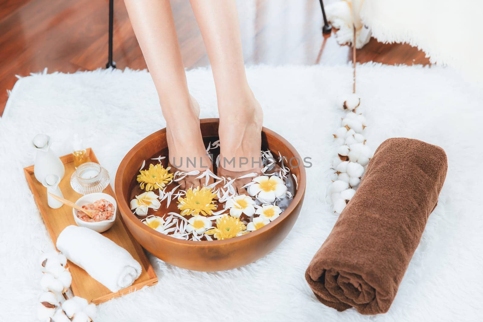 Woman indulges in blissful foot massage at luxurious spa salon while masseur give reflexology therapy in gentle day light ambiance resort or hotel foot spa. Quiescent