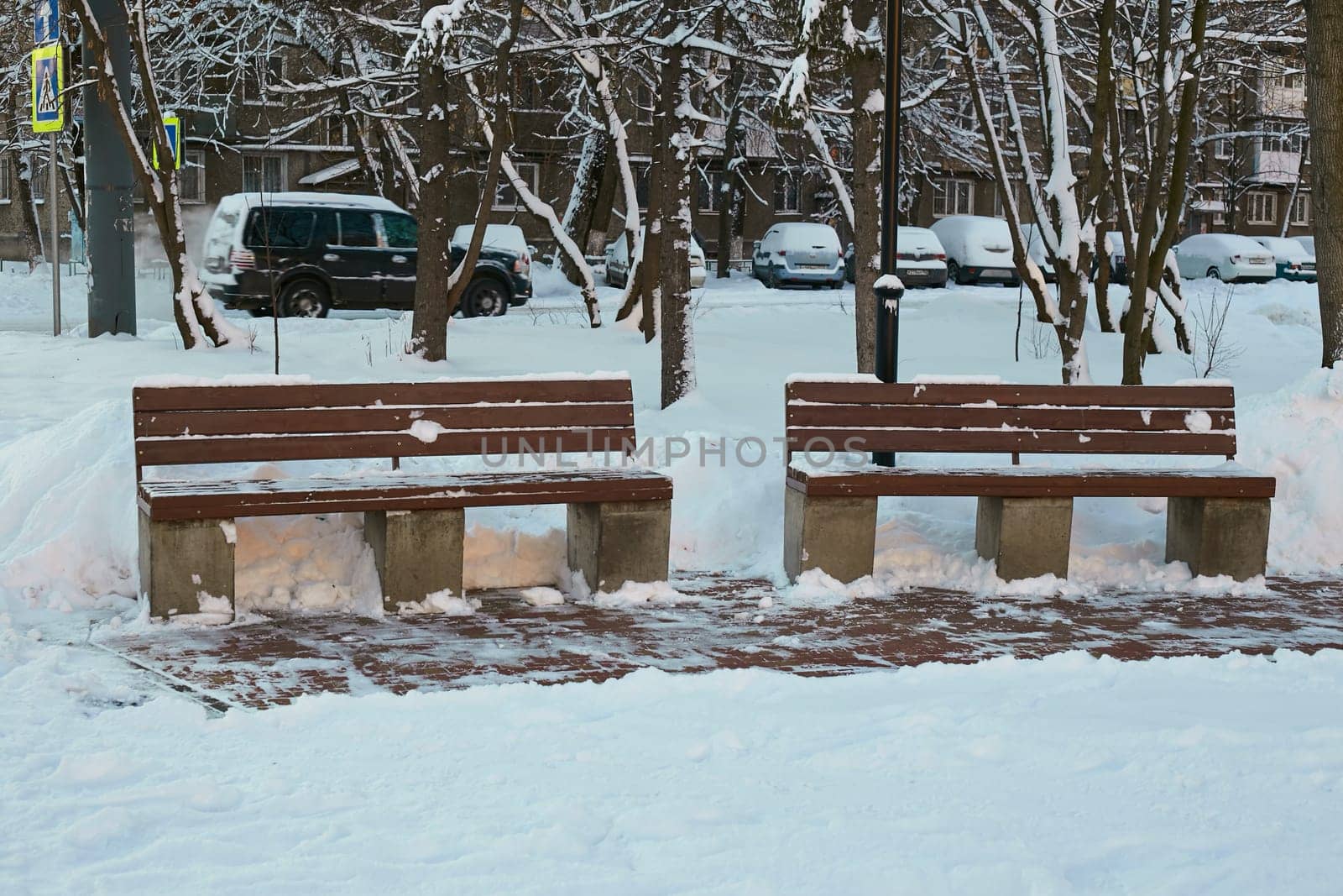 Photo two wooden benches in the snow in winter. The park is a place of rest.