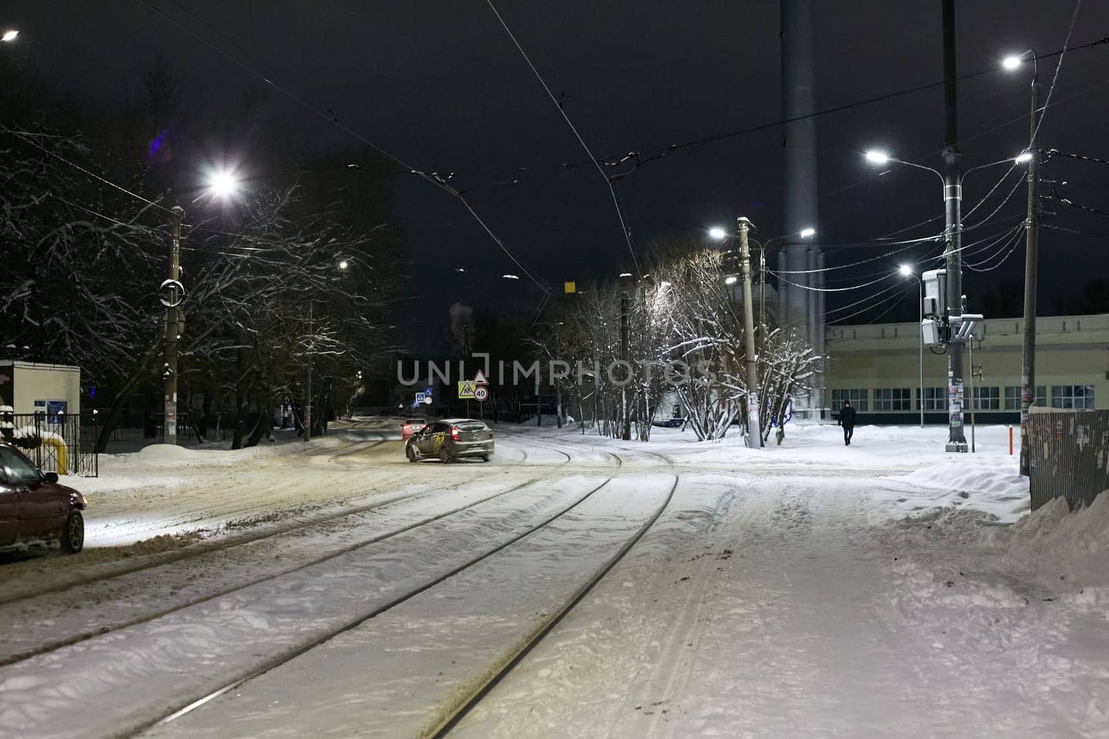 night time tram rails snow road . Public transport. by electrovenik