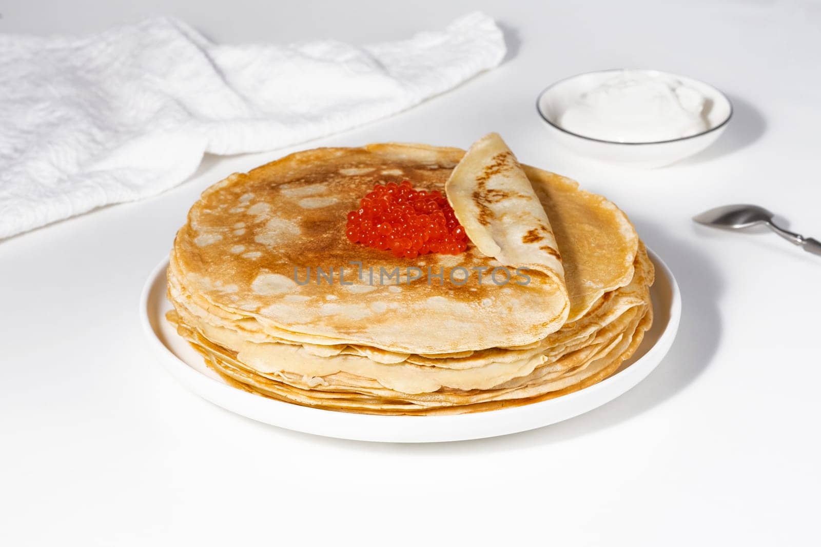 Pancakes with red caviar,Close-up of pancakes stacked on white background.