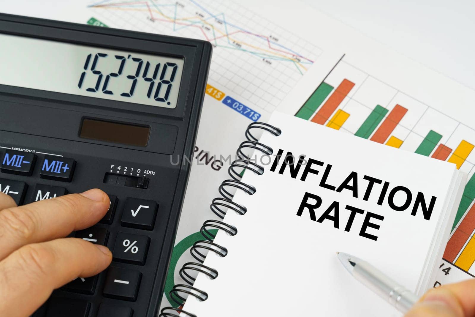 On the table there is a calculator, reports with graphs and a notepad with the inscription - Inflation rate by Sd28DimoN_1976