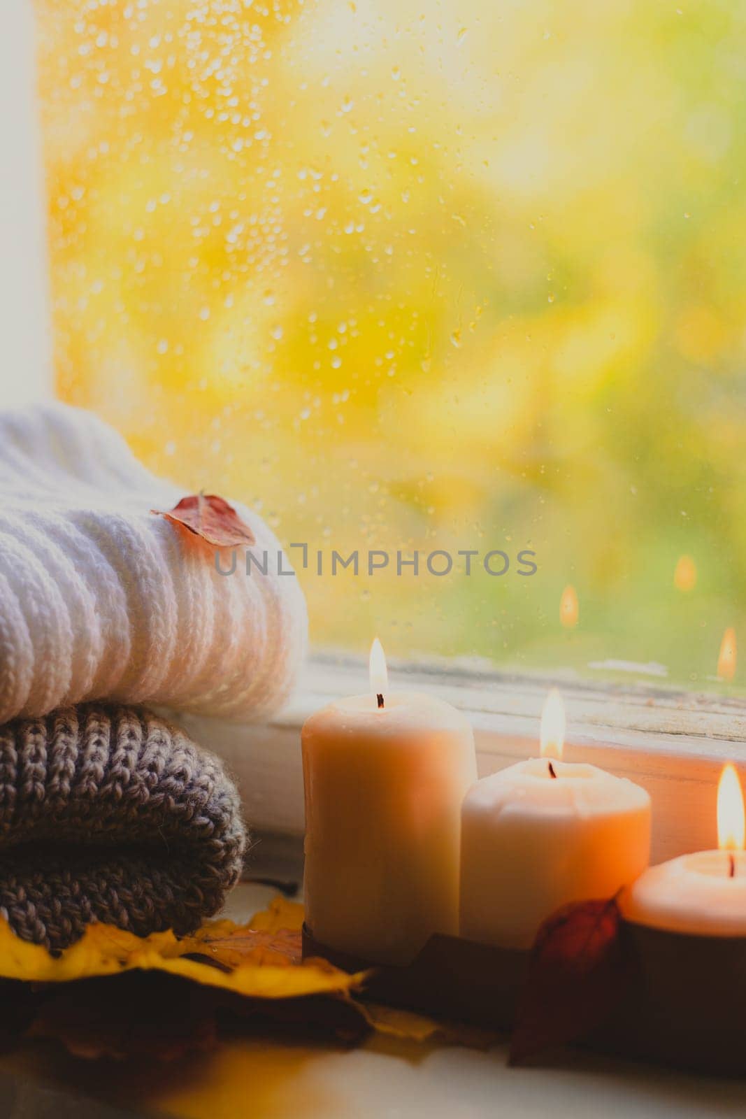 A burning candle on the window is autumn . the comfort of home . autumn comfort . autumn mood. The chondra .