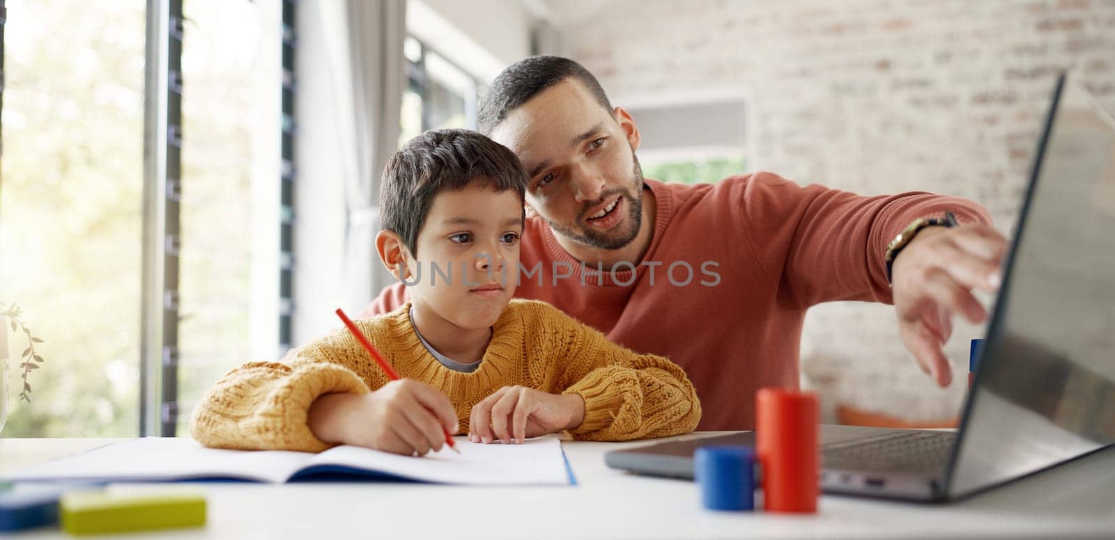 Father, boy child and homework with laptop, writing and helping hand for education, childhood development or care. Man, dad and male kid with home school, notebook and computer with teaching at desk.