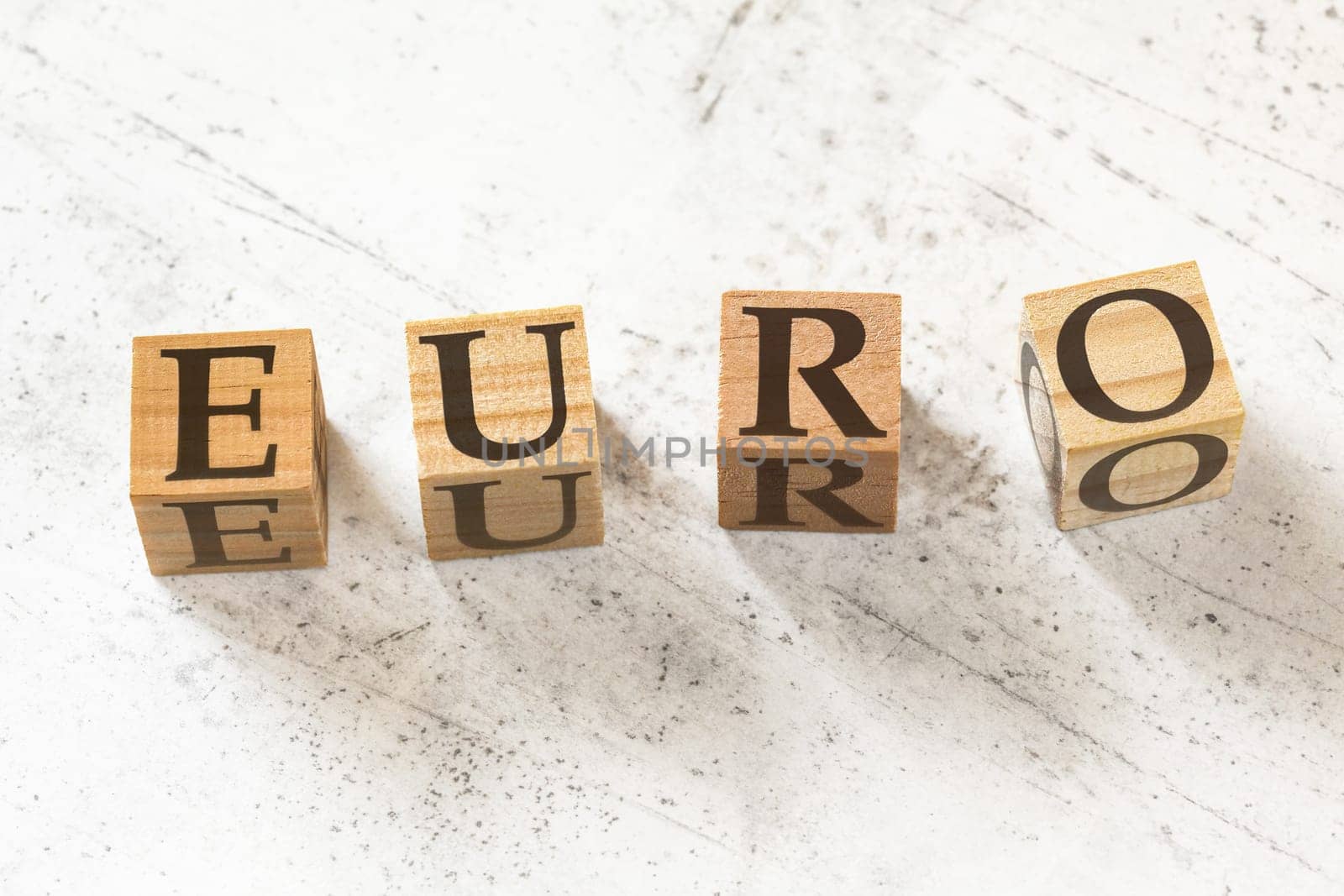 Four wooden cubes with word EURO on white working board by Ivanko