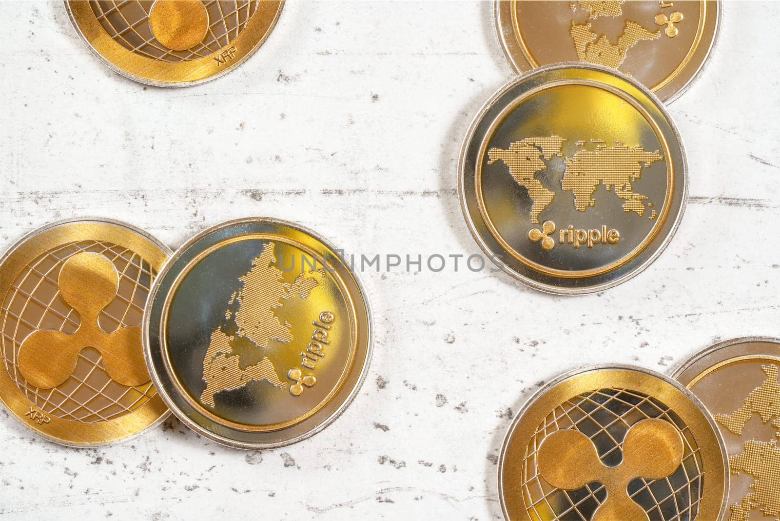 Top down view, golden XRP cryptocurrency -  ripple coins on white stone board by Ivanko