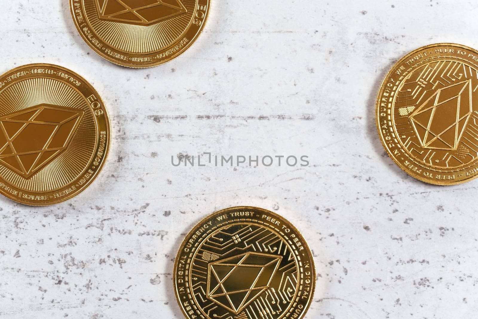 Golden commemorative EOS - EOSIO  cryptocurrency - coins on white stone board, flat lay view by Ivanko