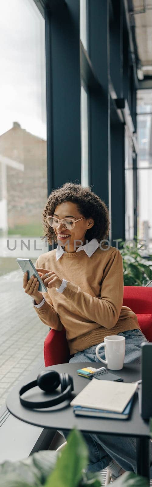 Smiling woman executive manager is using mobile phone sitting in office during break time