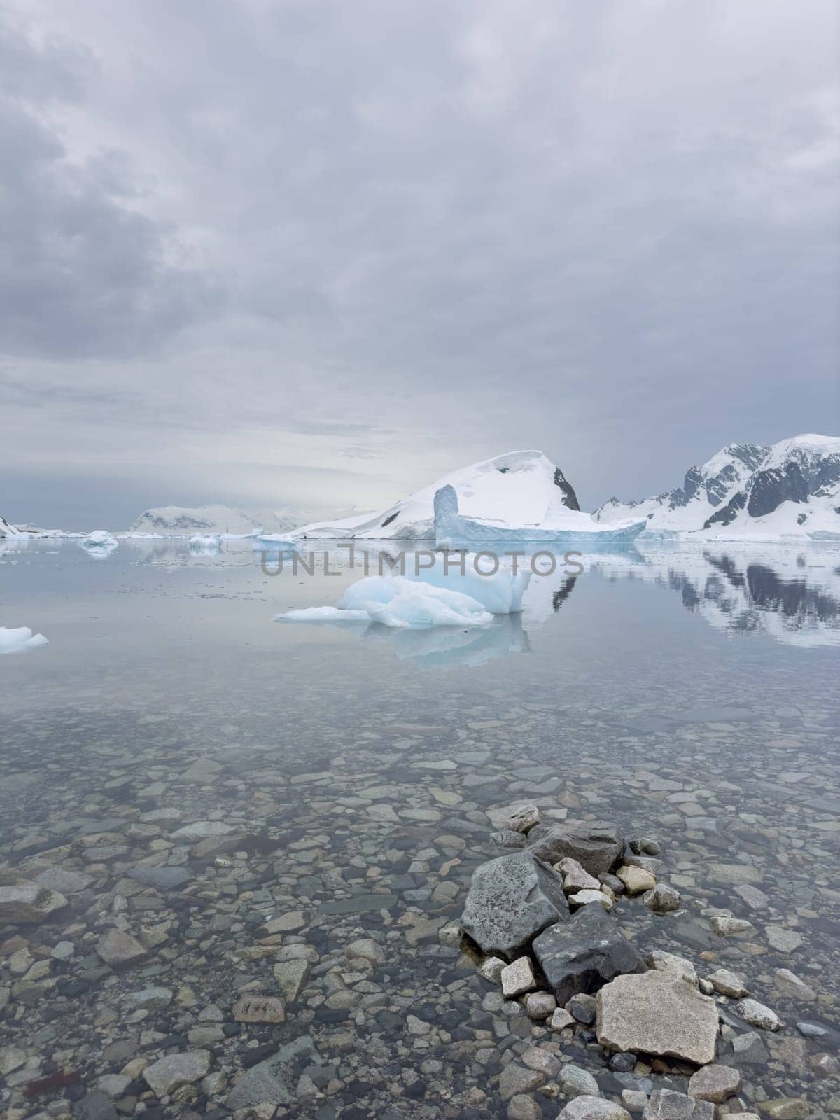 A huge high breakaway glacier in the southern ocean off the coast of Antarctica, the Antarctic Peninsula, the Southern Arctic Circle, azure water, cloudy weather. High quality photo