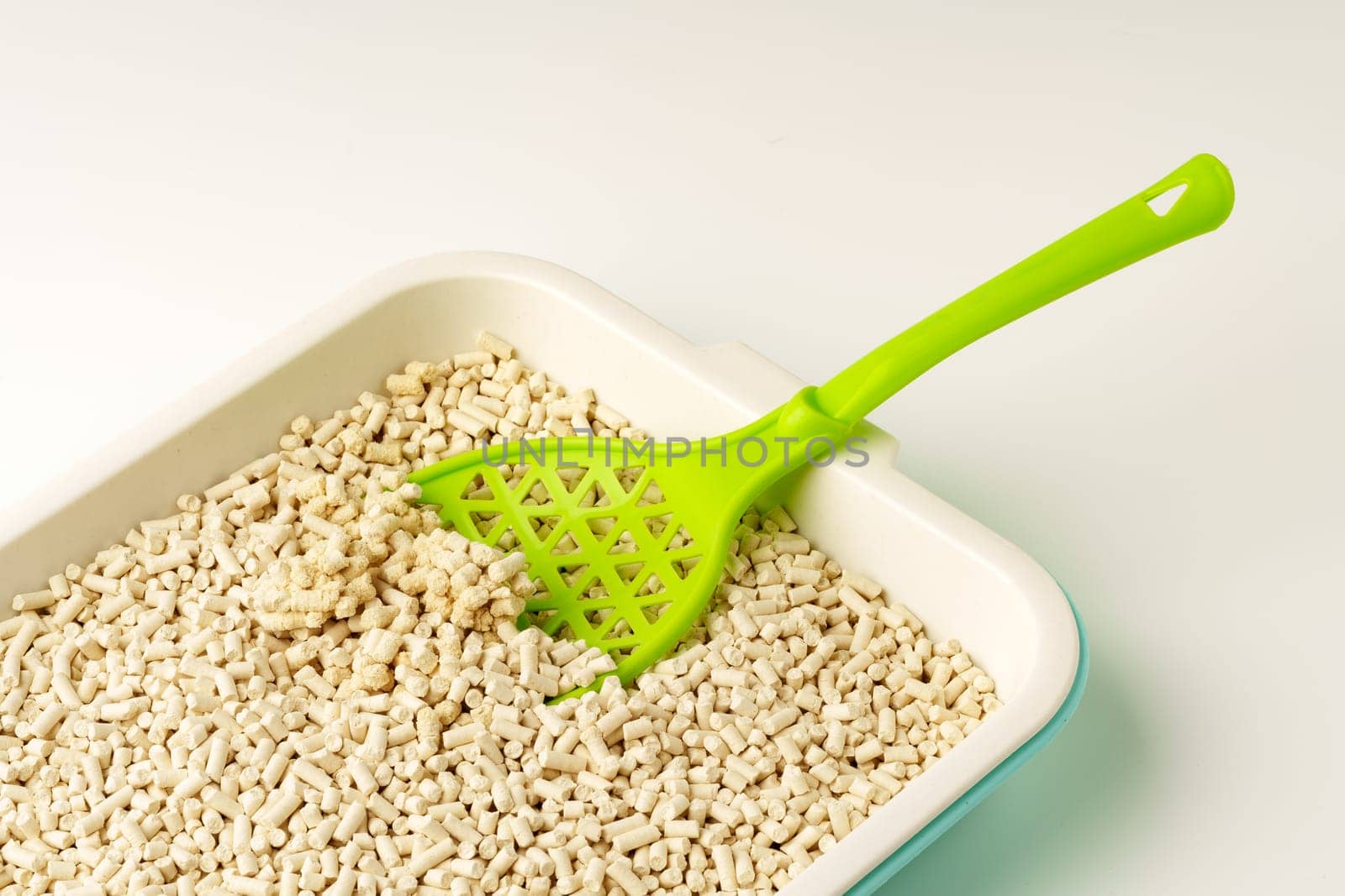 Wooden pet litter filler with scoop isolated on white background close up