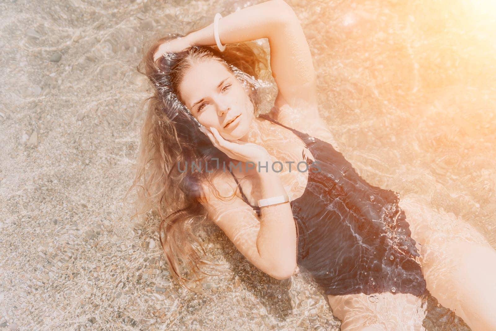 Woman summer travel sea. Happy tourist enjoy taking picture outdoors for memories. Woman traveler posing on the beach at sea surrounded by volcanic mountains, sharing travel adventure journey by panophotograph