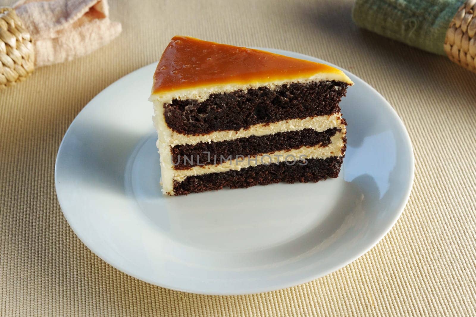 Piece of cake sits elegantly on a pristine white plate, offering a mouthwatering treat.