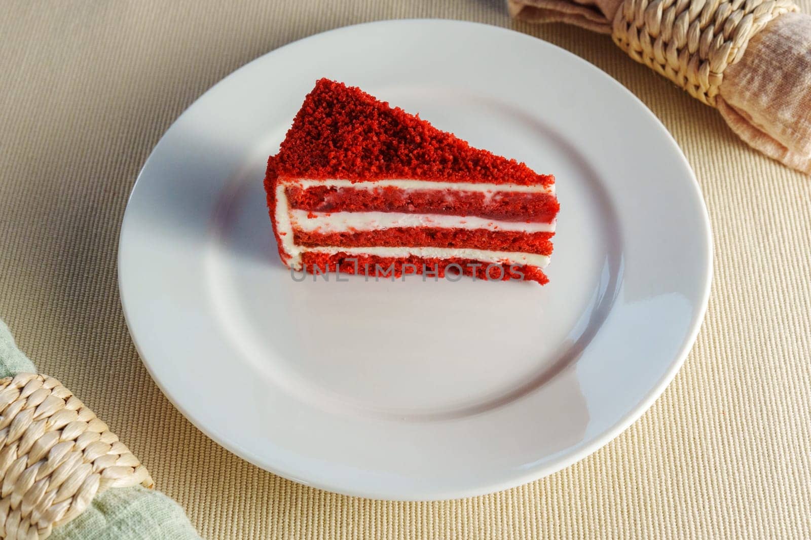 Piece of red velvet cake rests on a pristine white plate, inviting you to savor its rich flavors with every bite. by darksoul72