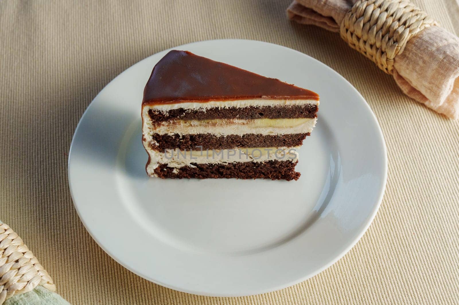Delicate Slice: Decadent Chocolate Cake Perched on a Gleaming White Plate