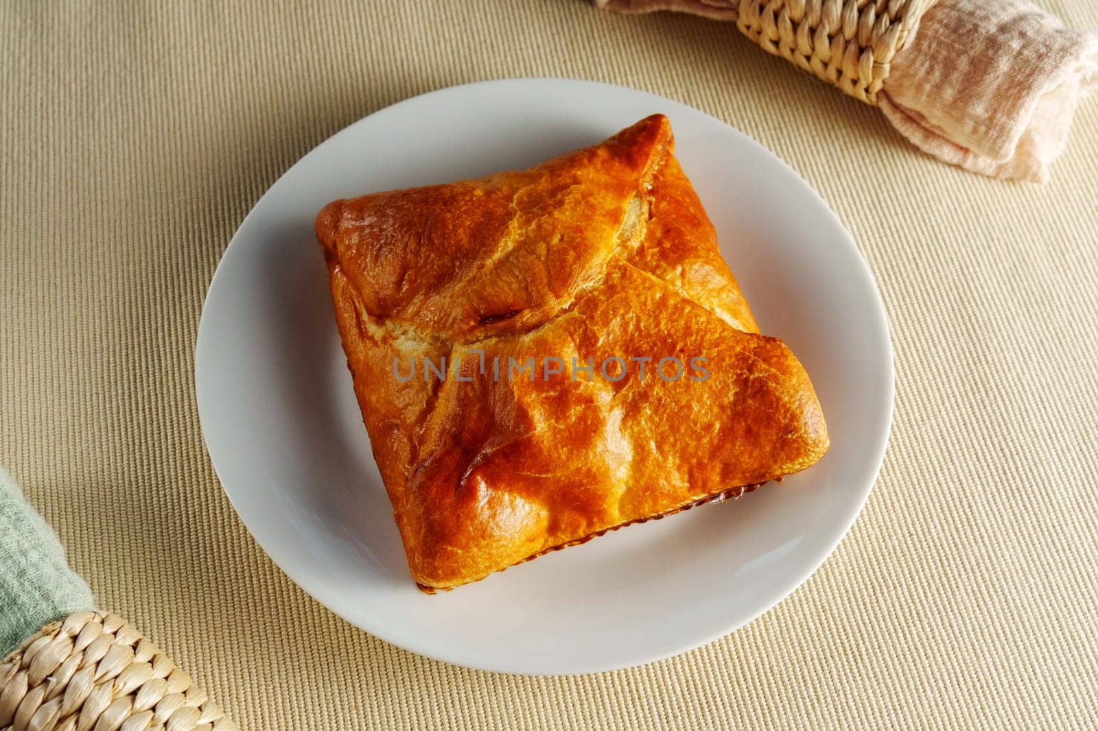 A visually stunning composition featuring a perfectly baked puff pastry adorning a pristine white plate.