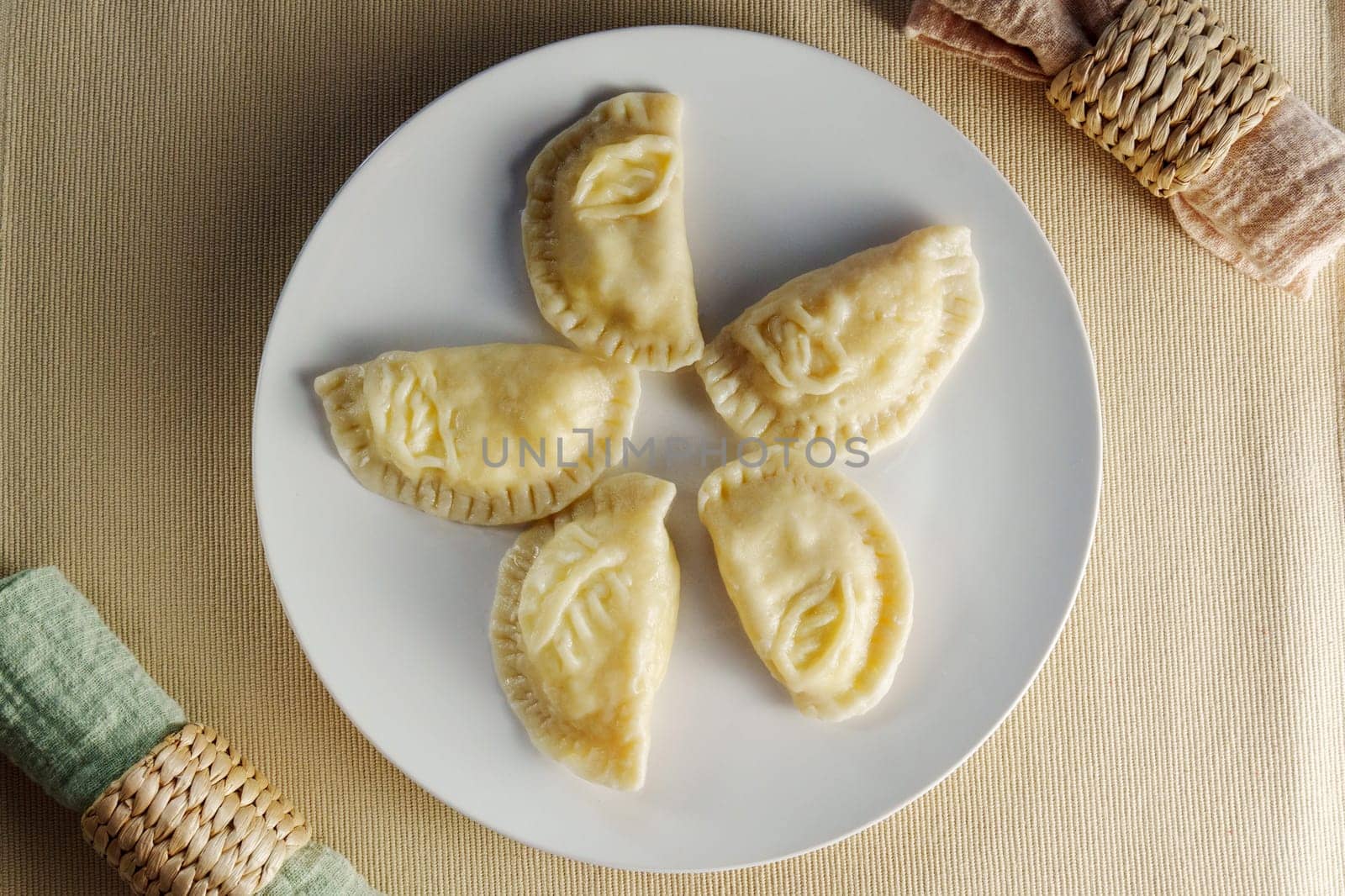Elegance of perfectly crimped crescent dumplings, or ravioli, presented on a white plate, ready to entice any food connoisseur. by darksoul72