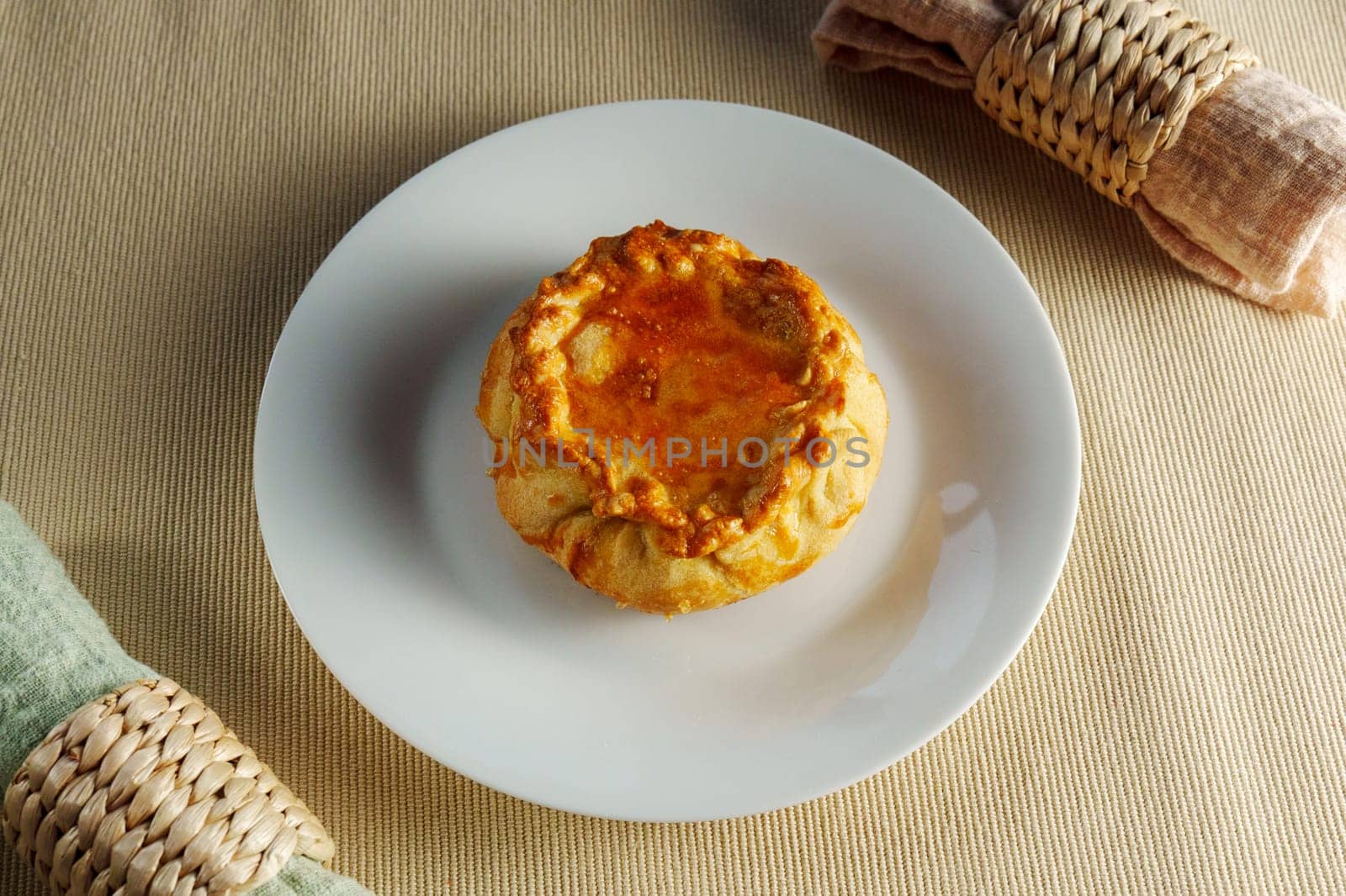 A Flaky Delight: A White Plate Showcasing a Delectable Pastry on a Mesmerizing Table