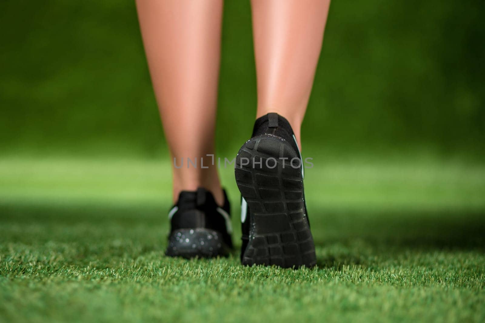 His feet beautiful woman in the shoes are on a grass. Close up by nazarovsergey