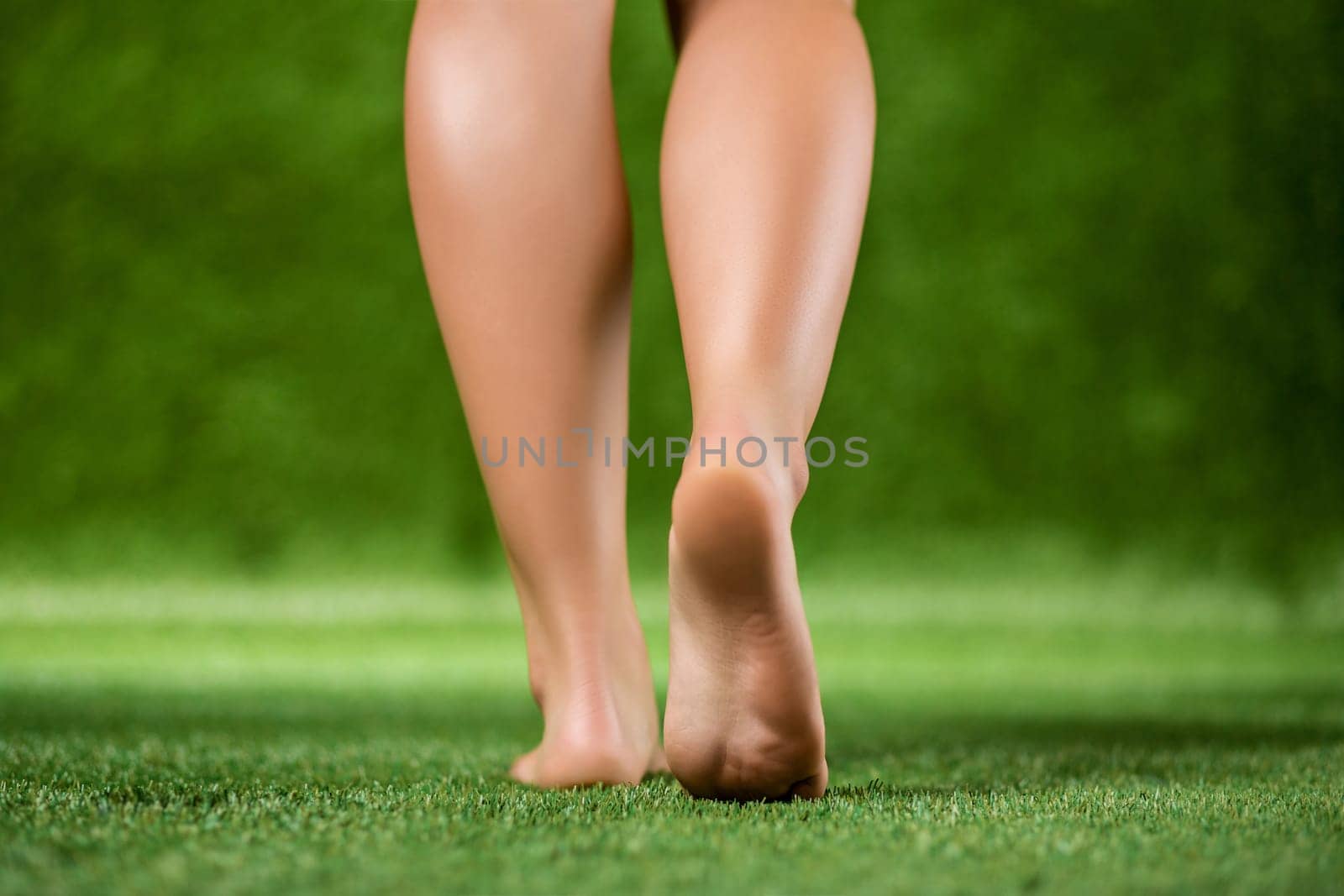 His bare feet beautiful woman close up are on a grass. by nazarovsergey