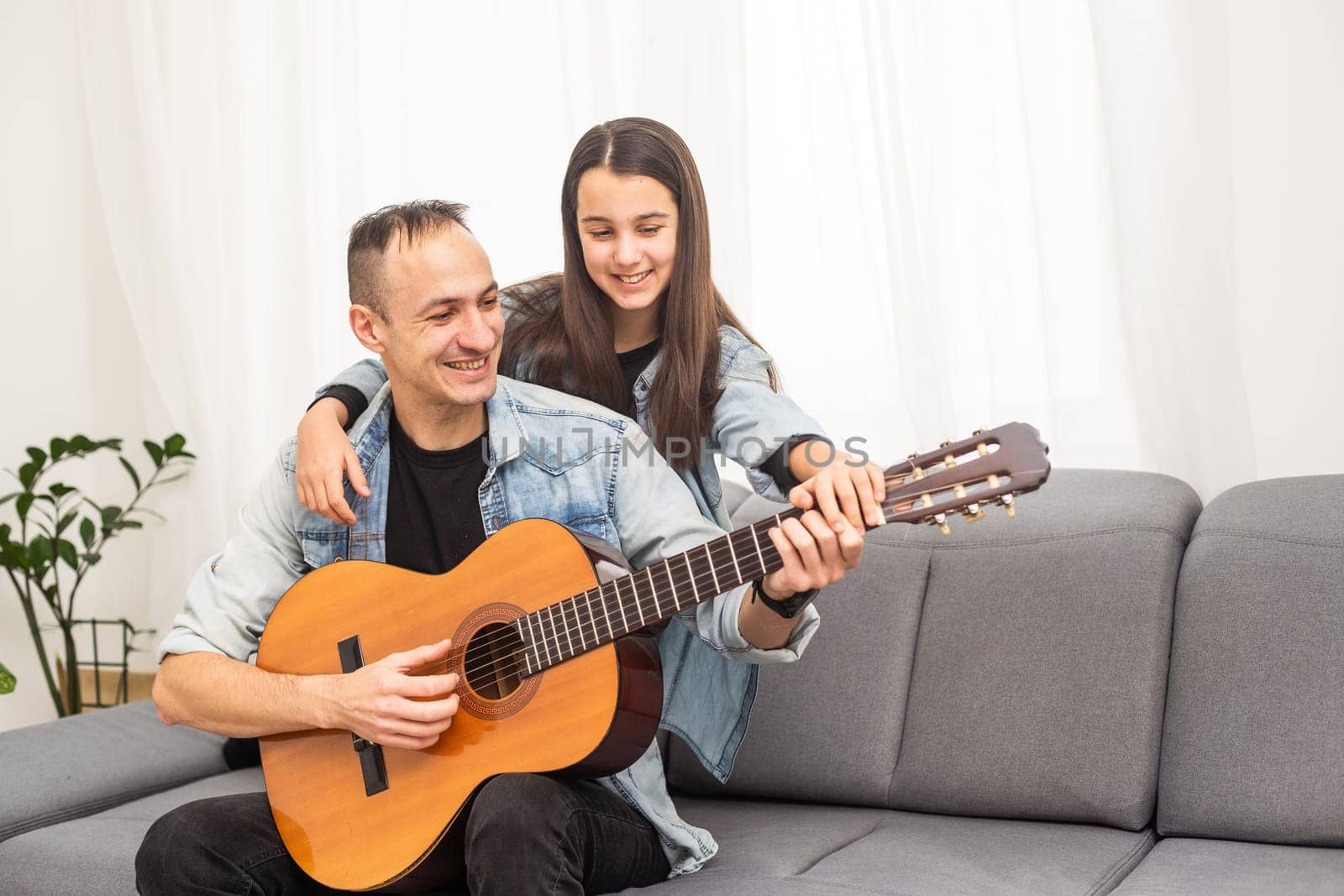 Guitar teacher teaching the little girl by Andelov13