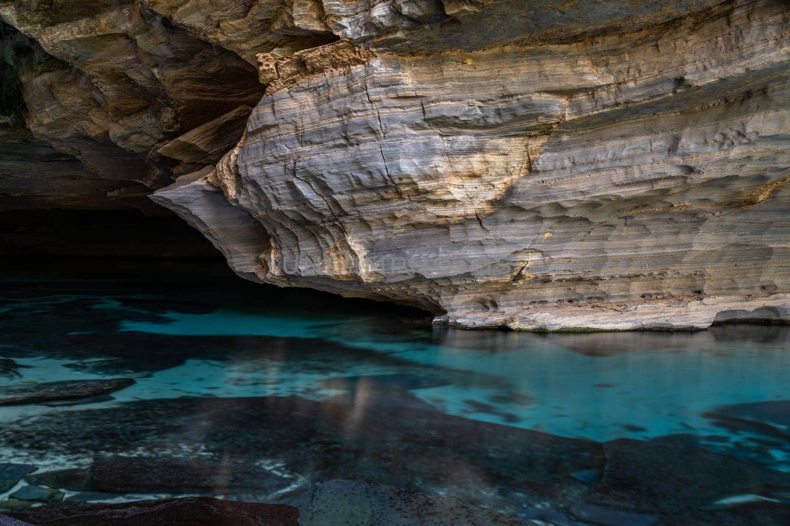 Serene Waters Beneath Ancient Stratified Rock Formations by FerradalFCG