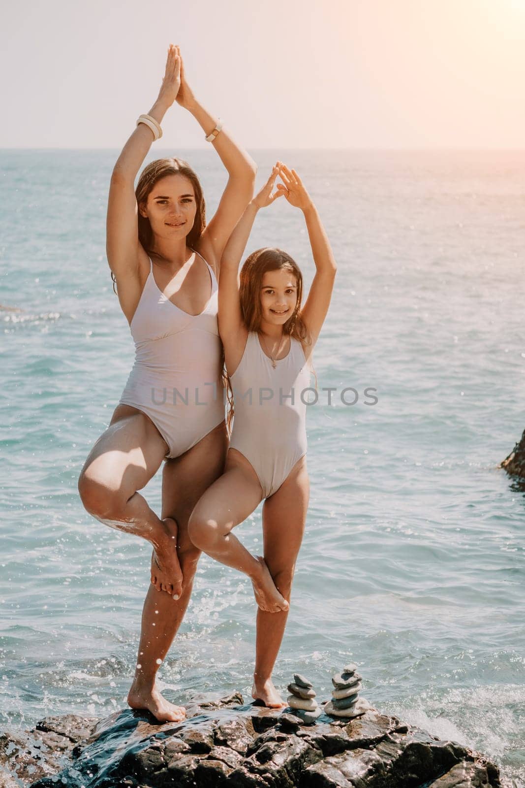 Silhouette mother and daughter doing yoga at beach. Woman on yoga mat in beach meditation, mental health training or mind wellness by ocean, sea