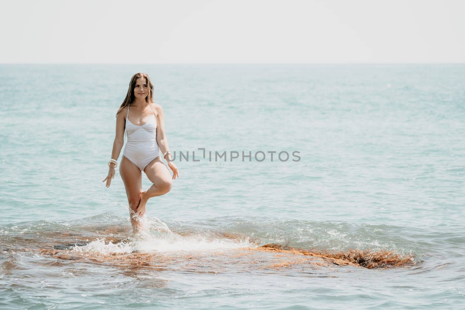 Woman sea yoga. Back view of free calm happy satisfied woman with long hair standing on top rock with yoga position against of sky by the sea. Healthy lifestyle outdoors in nature, fitness concept.