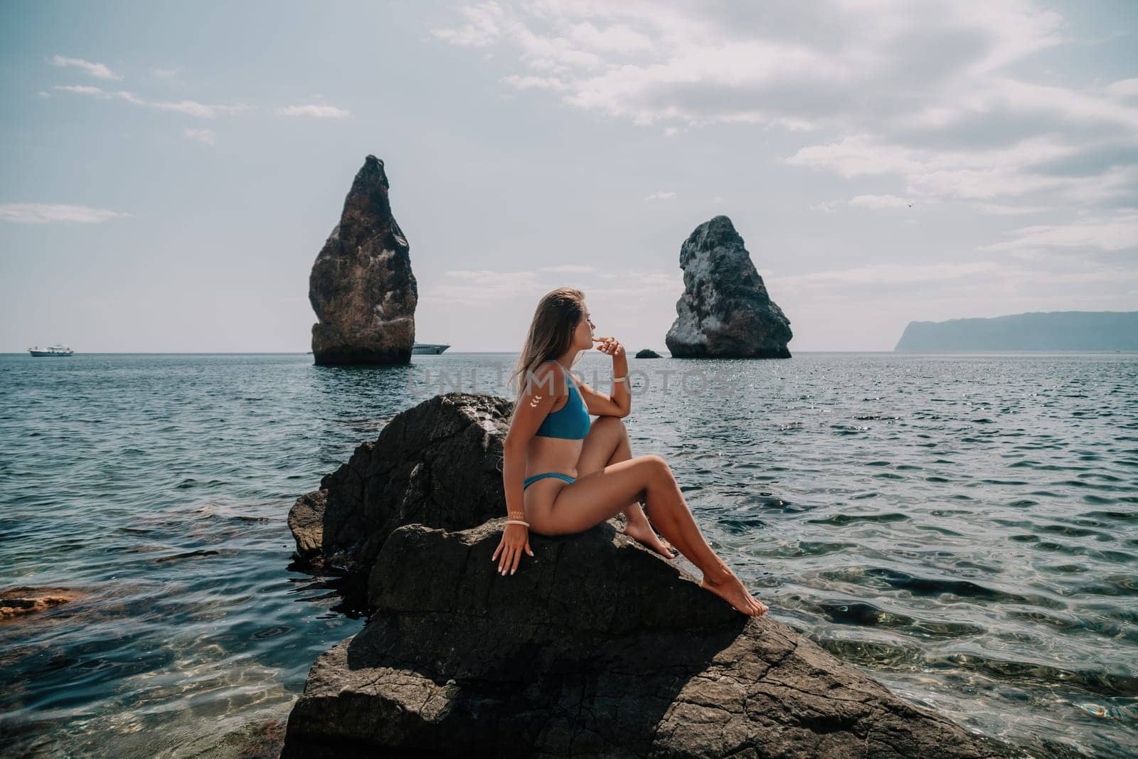 Woman summer travel sea. Happy tourist enjoy taking picture outdoors for memories. Woman traveler posing on the beach at sea surrounded by volcanic mountains, sharing travel adventure journey by panophotograph