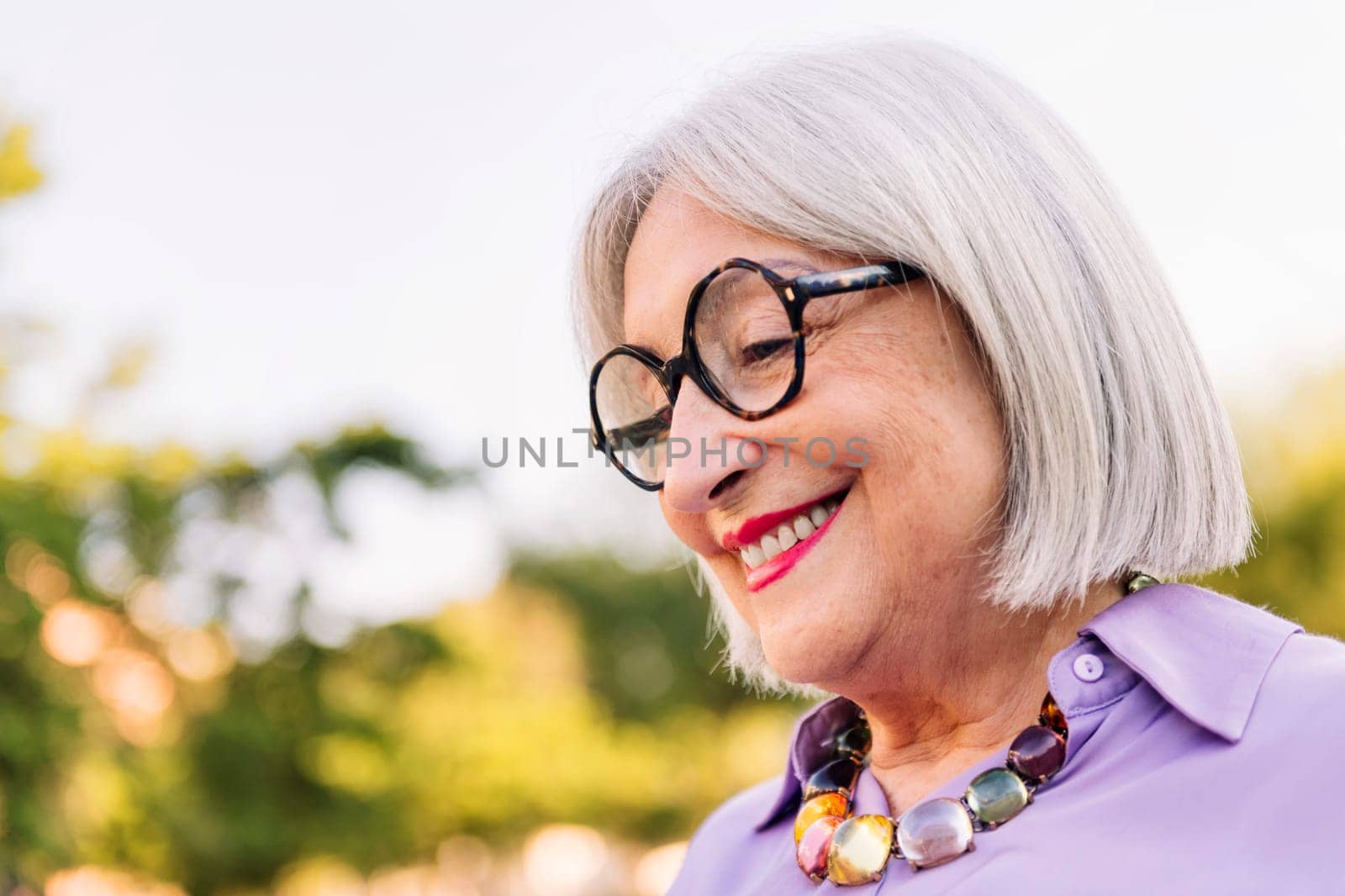 portrait of a beautiful senior woman with glasses smiling, concept of elderly people leisure and happiness in old age, copy space for text