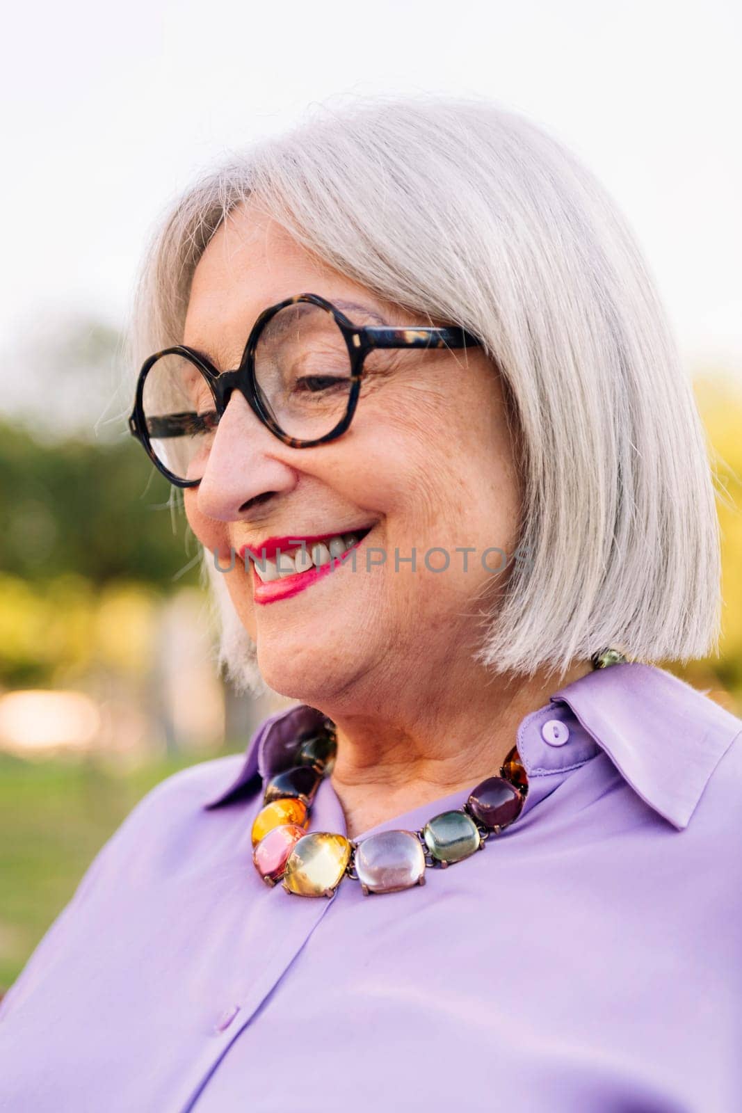 portrait of a beautiful senior woman with glasses smiling, concept of elderly people leisure and happiness in old age