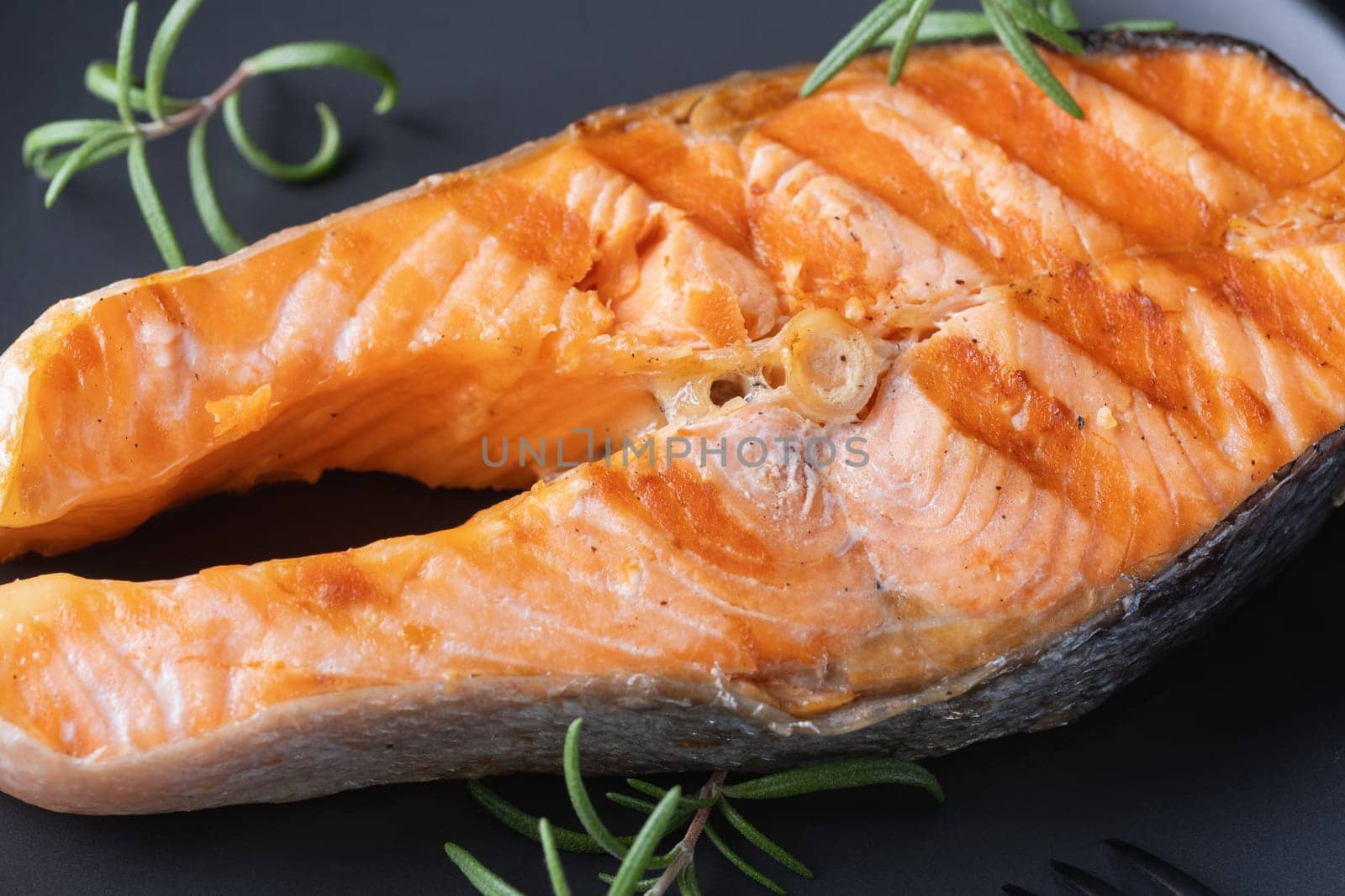 Grilled salmon on grey plate.