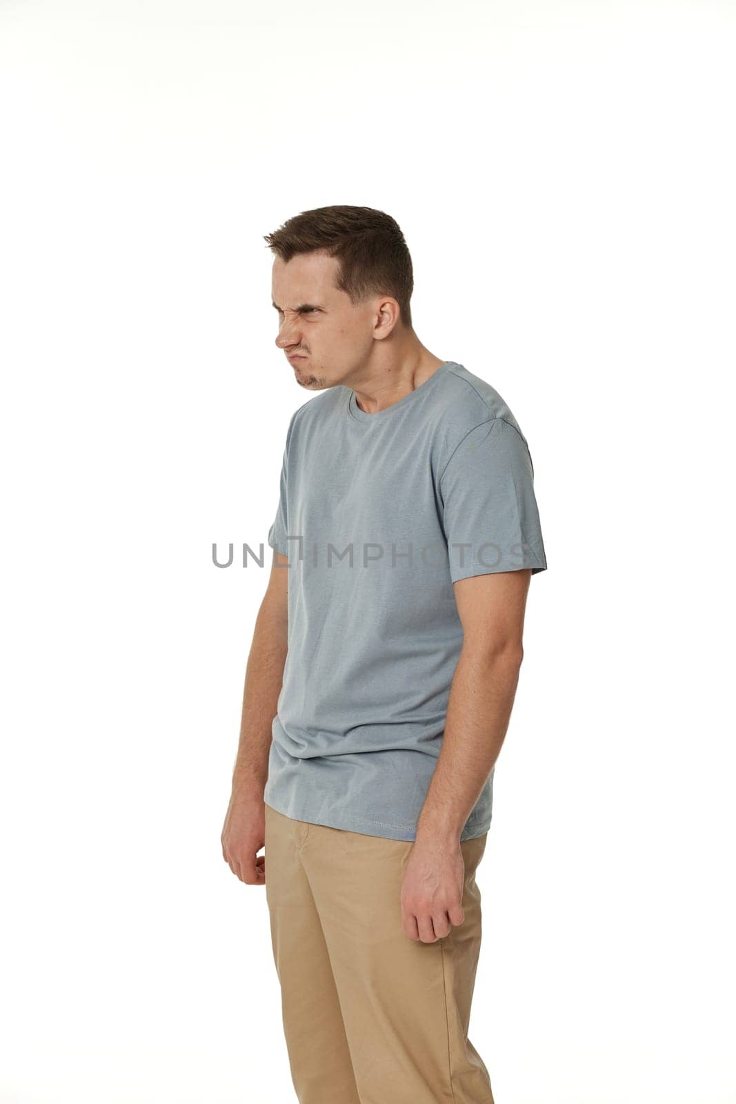 annoyed angry man standing on white studio background