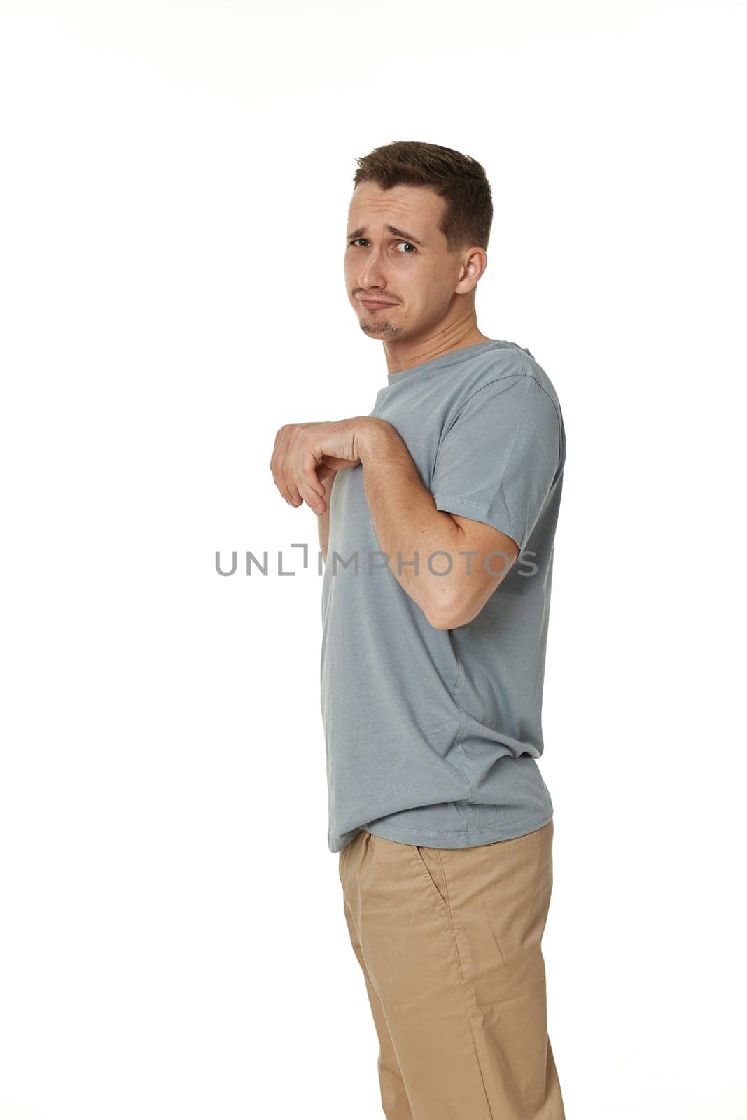 portrait of young funny man grimacing on white background
