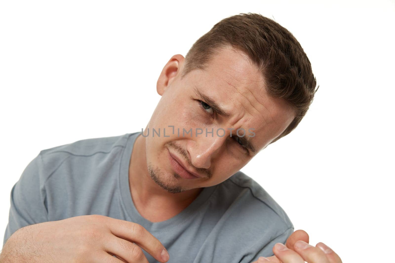 Portrait of offended frustrated young man on white background.