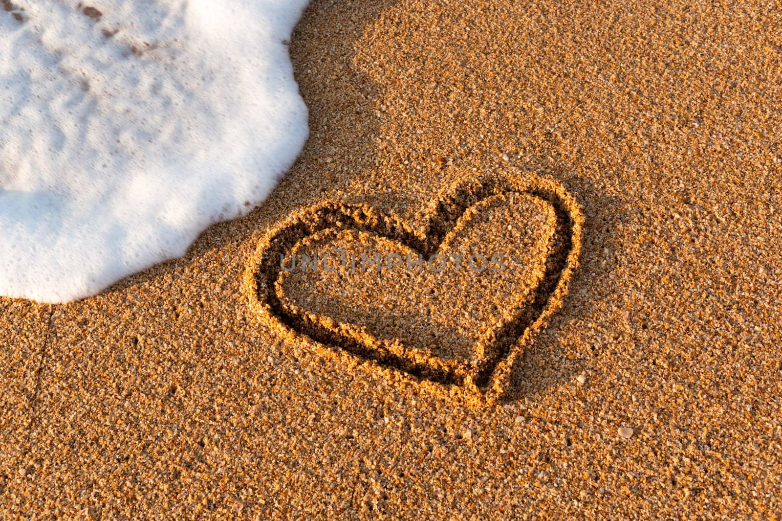 Heart drawn in the sand on the beach at sunset. Heart shape. Heart symbol. Love. Sea foam by yanik88