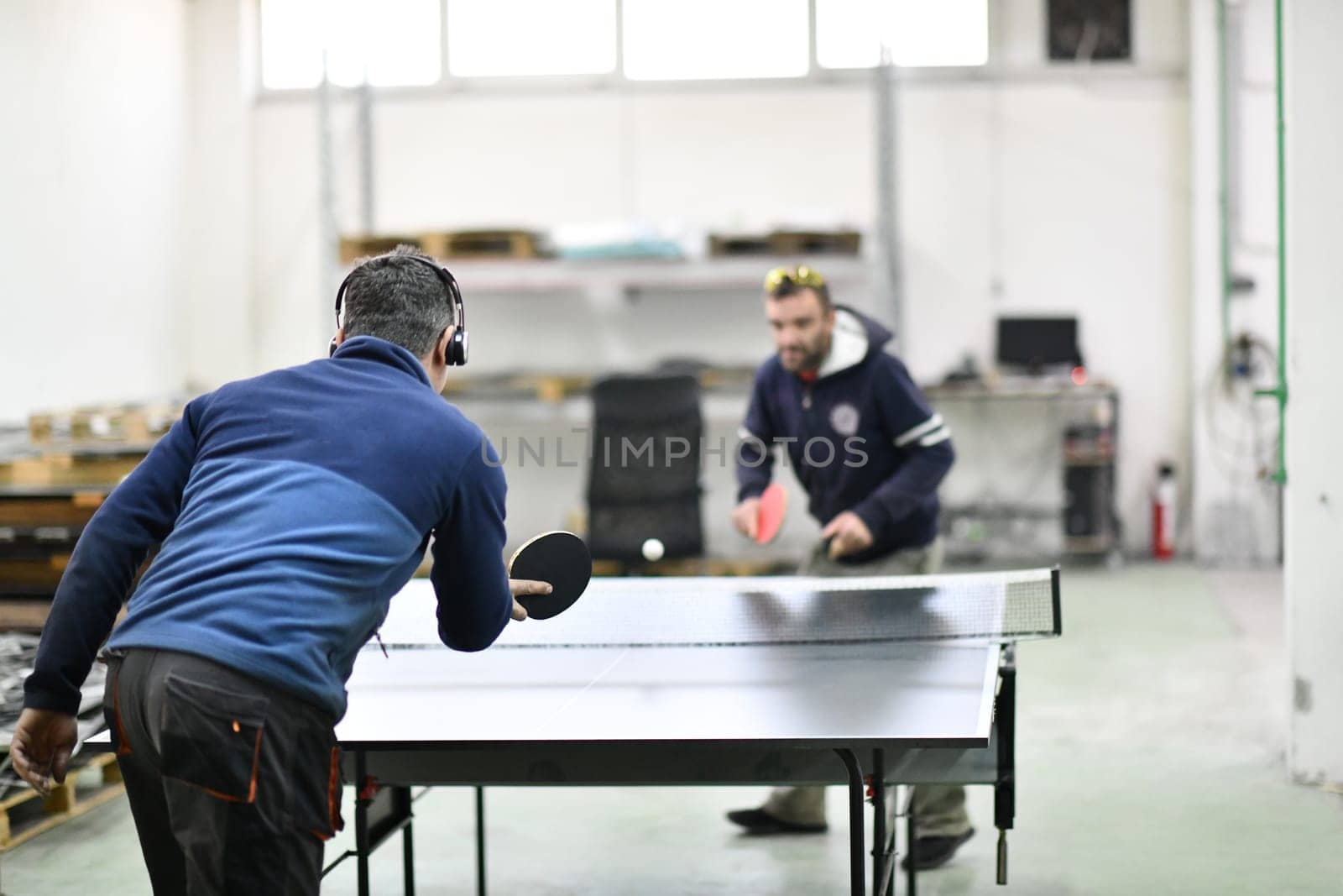 industry workers table tennis game and relaxing in their free time by dotshock