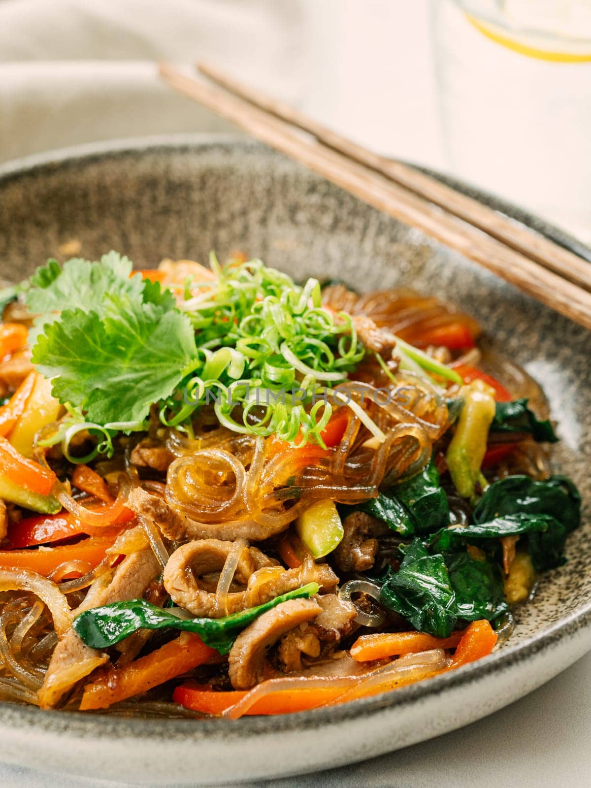 Asian noodles with meat and vegetables. Stir fry noodles with vegetables and beef, pork or chicken. Plate of asian buckwheat soba noodles with vegetables and chicken.