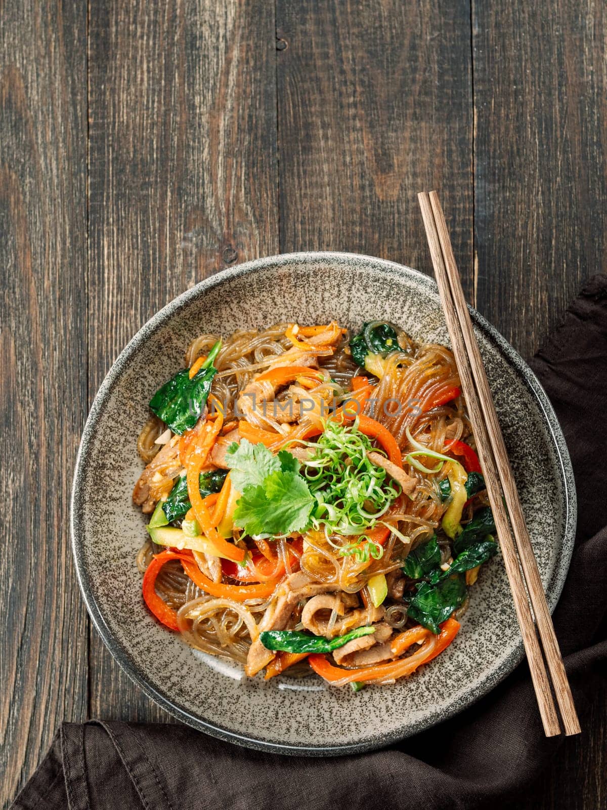 Asian noodles with meat and vegetables. Stir fry noodles with vegetables and beef, pork or chicken. Plate of asian buckwheat soba noodles with vegetables and chicken.