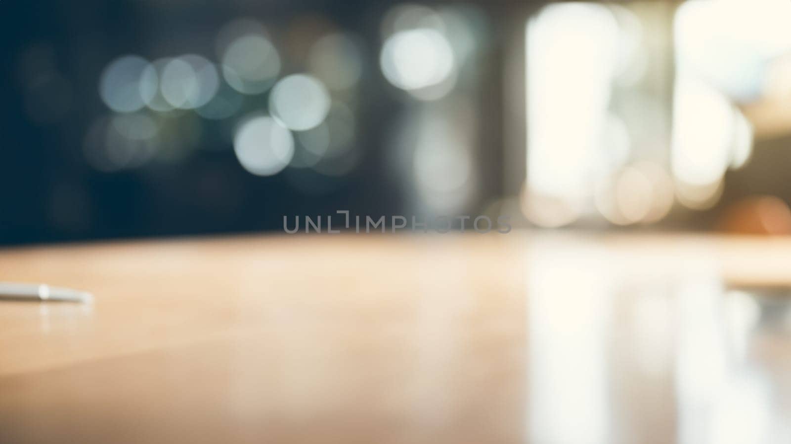 Blurred serene, unoccupied workspace bathed in natural light. Wooden desk with reflection. Minimalist beauty of uncluttered desk. Blurred Abstract Bokeh background for design by DesignMarjolein
