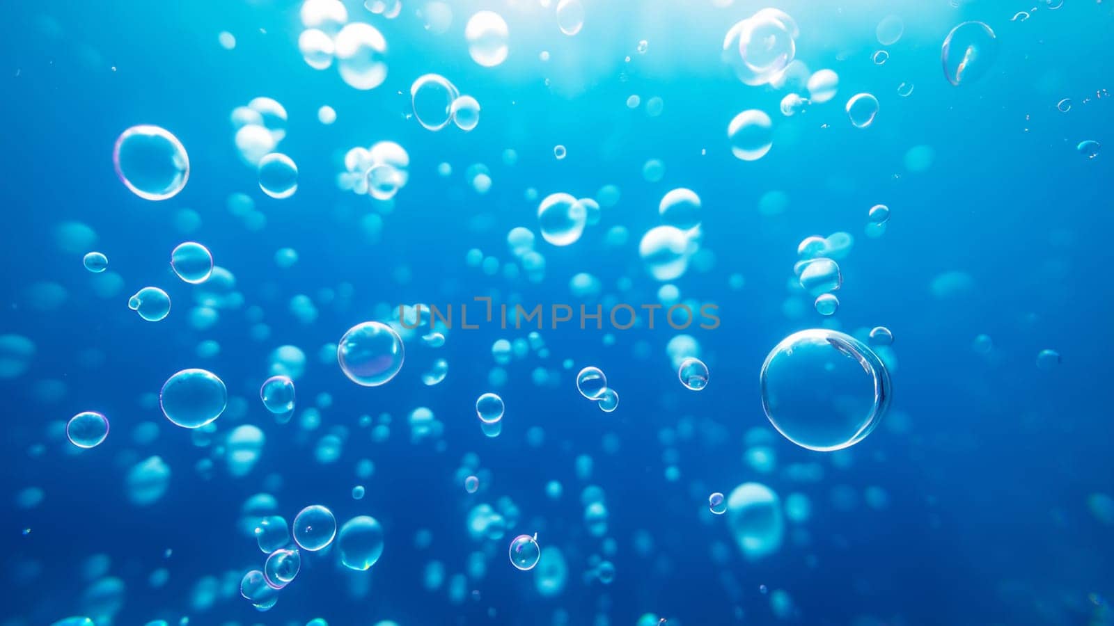 Bubbles up close in blue water. Underwater background with air bubbles.