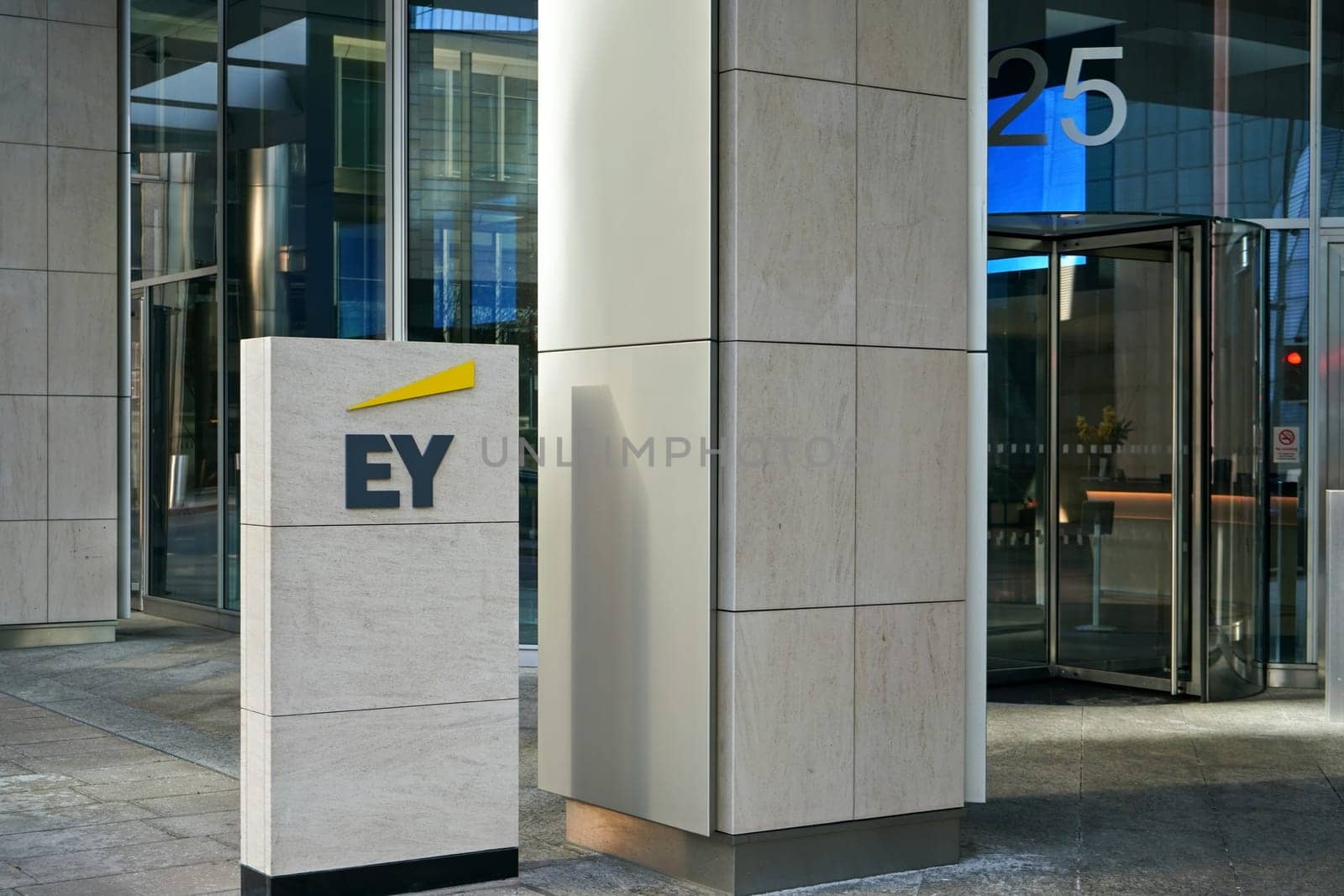 London, United Kingdom - February 03, 2019: Blue and yellow EY signage at entrance to their office in Canary Wharf. It is UK professional services company, one of big 4 accounting firms by Ivanko