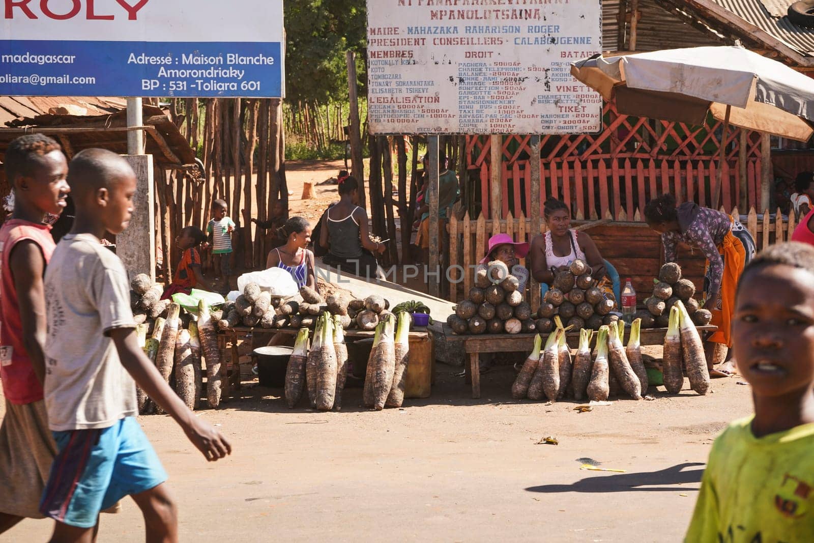 Toliara, Madagascar - May 05, 2019: Unknown Malagasy local women selling food - mostly tubers - near dusty road. There are not many shops, goods are usually sold on streets in this region. by Ivanko