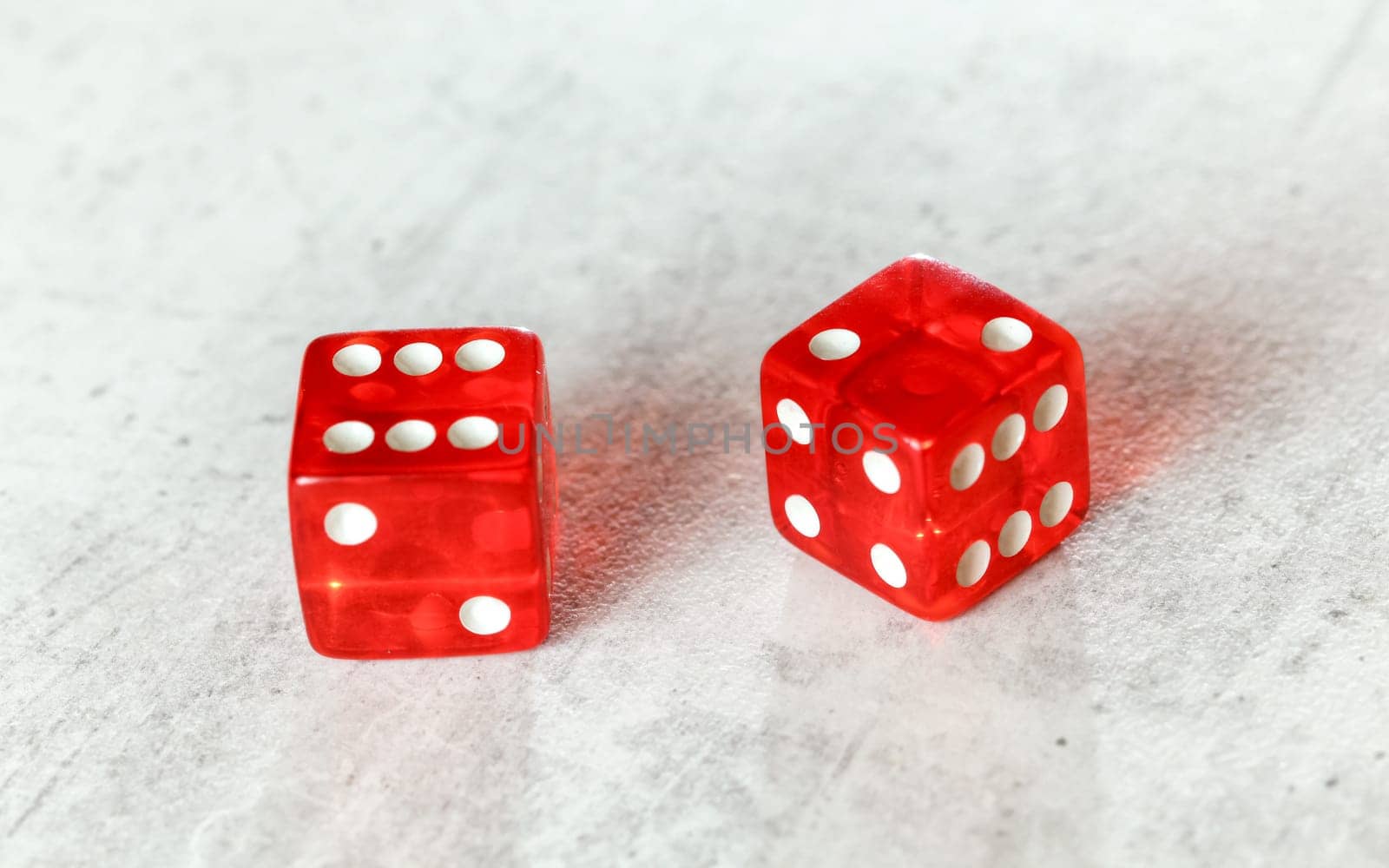 Two translucent red craps dices on white board showing Easy Eight (number 6 and 2) by Ivanko