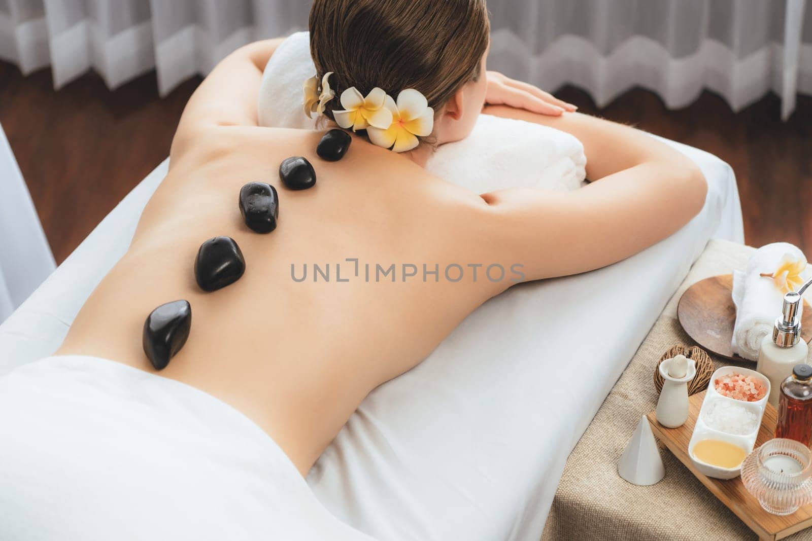 Hot stone massage at spa salon in luxury resort. Quiescent by biancoblue