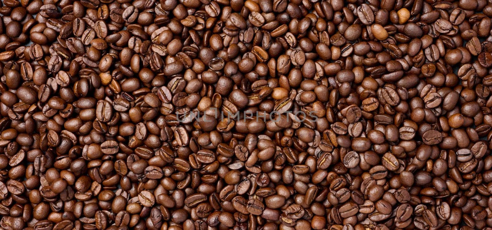 Scattered roasted coffee beans, full frame