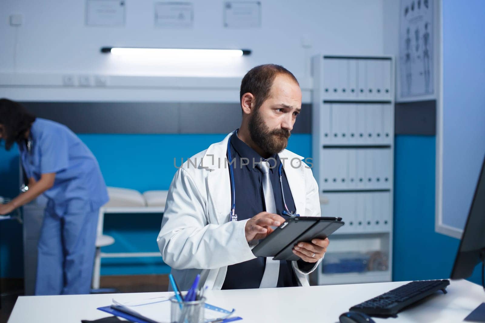 Doctor utilizing technology in a clinic by DCStudio