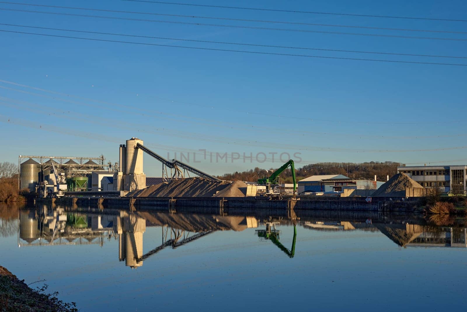 Riverside Manufacturing Hub. Eco-Friendly Technology and Production. Explore the synergy of technology and production at the Riverside Manufacturing Hub, nestled by the river. Witness the balance between industry and the environment, showcasing the integration of sustainable practices. This image captures the essence of eco-friendly manufacturing and its harmonious coexistence with the surrounding natural beauty.